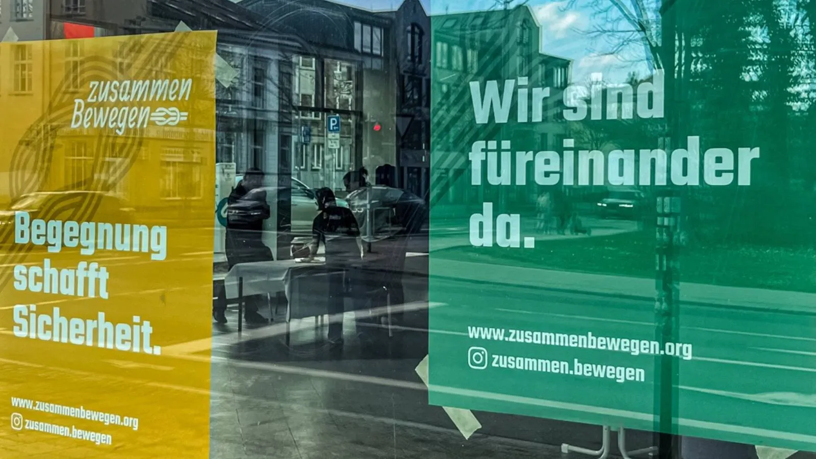 "Zusammen bewegen"-Plakate in einem Schaufenster.